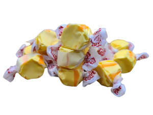 Yellow and orange colored taffy wrapped in decorated wax paper 