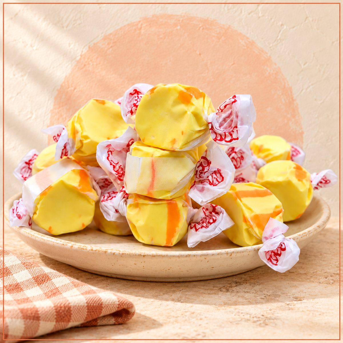 Yellow and orange colored taffy wrapped in decorated wax paper
