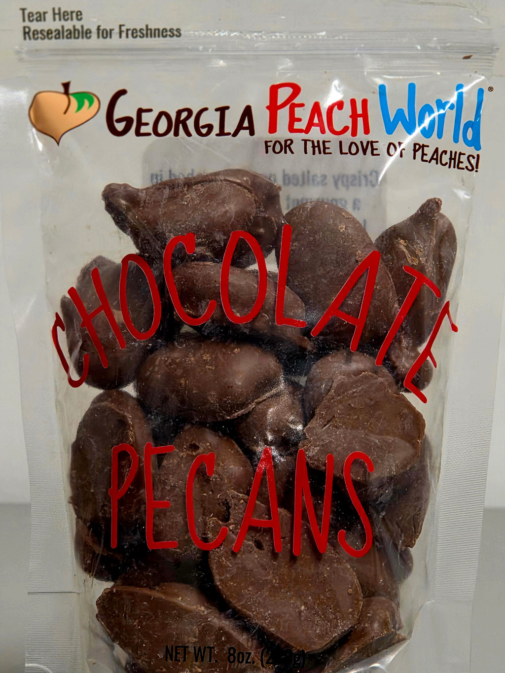 Bag of chocolate pecans with 'Georgia Peach World' branding on a white background