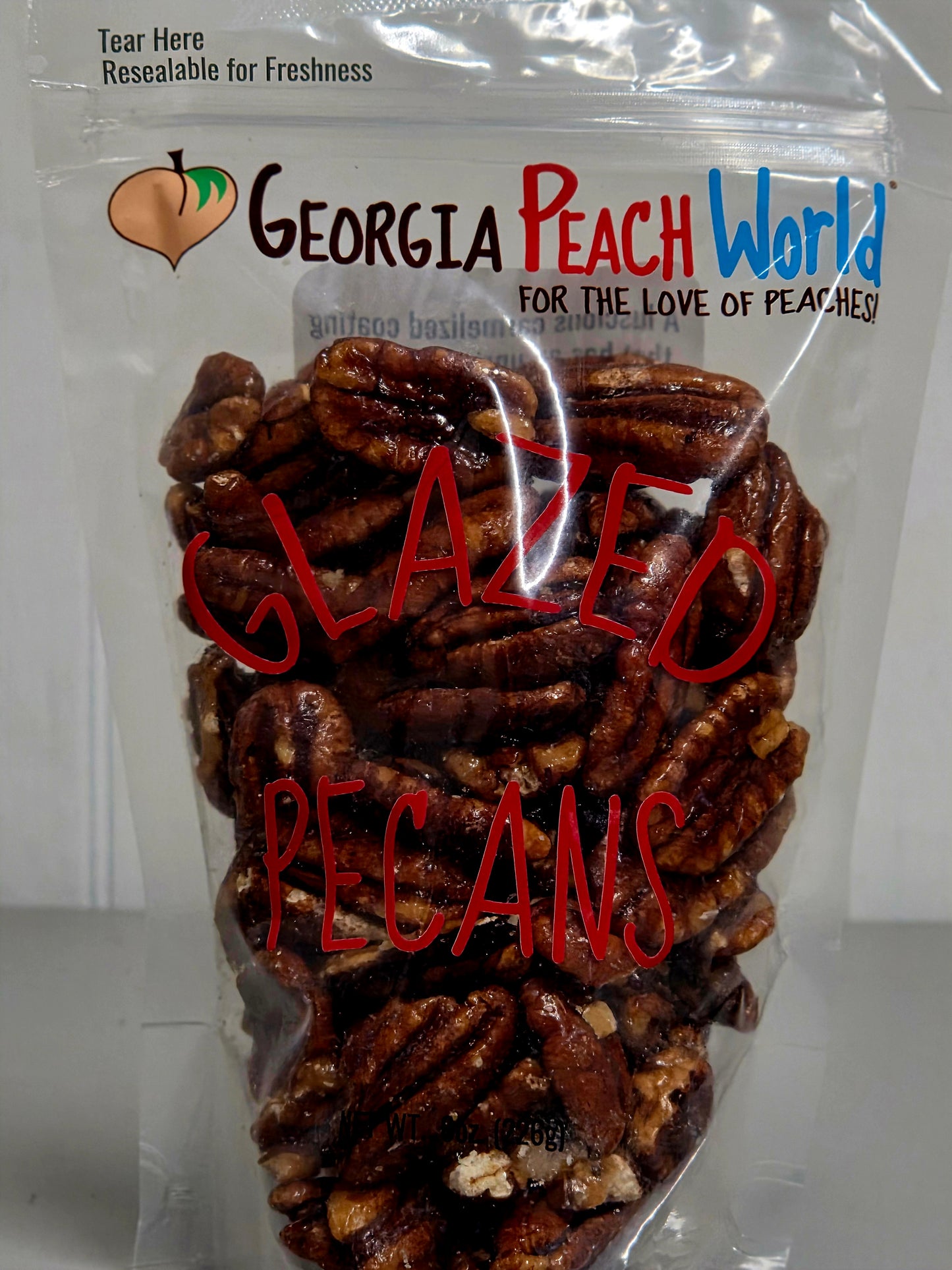 Packaged glazed pecans with 'Georgia Peach World' branding on a white background