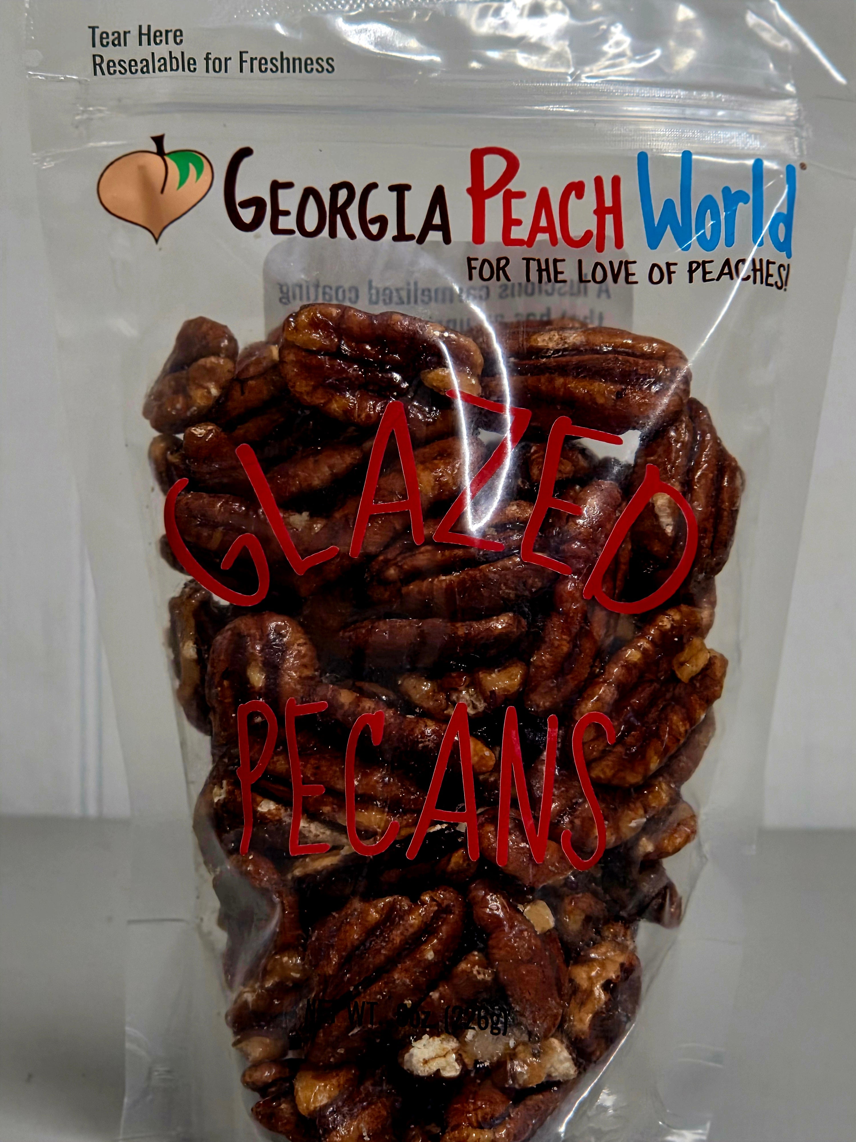 Packaged glazed pecans with 'Georgia Peach World' branding on a white background