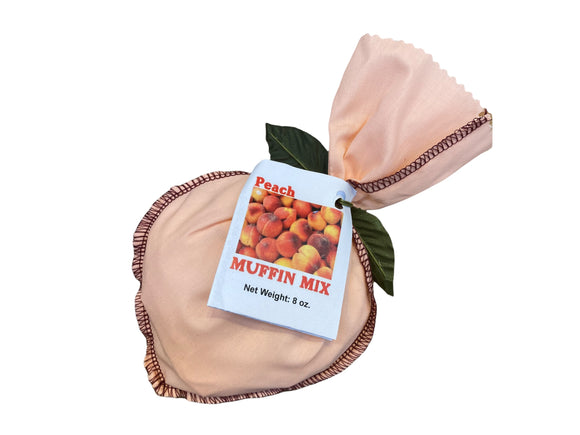 Powdered ingredients wrapped in a pink peach shaped cloth bag decorated with a green leaf. Instructions are twist tied to the bag.