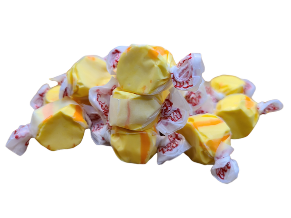 Yellow and orange colored taffy wrapped in decorated wax paper 