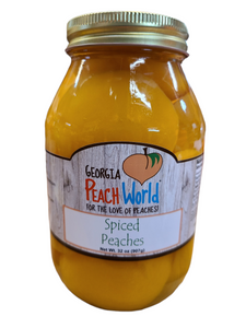 Quart sized glass jar containing skinless peach halves in clove spiced water