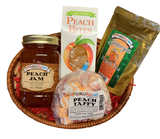 Small oval shaped wicker basket with crinkle paper, a Standard glass Mason Jar containing peach jam, small cardboard carton of peach hard candy, gold 2 oz foil pack containing loose leaf peach tea, and plastic packaged orange and white colored taffy wrapped in wax paper