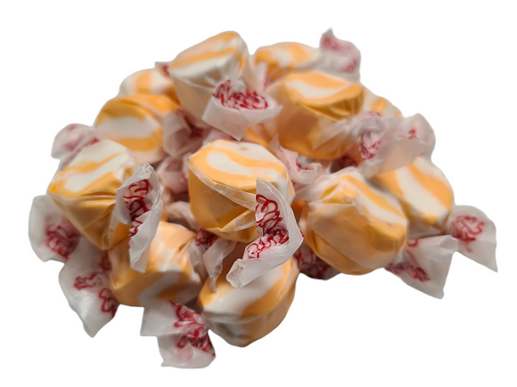 Orange and white swirled taffy wrapped in wax paper