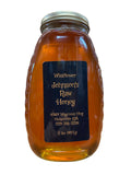 Tall thin and wide traditional queenline shape with ribbed edges glass jar containing raw wildflower honey