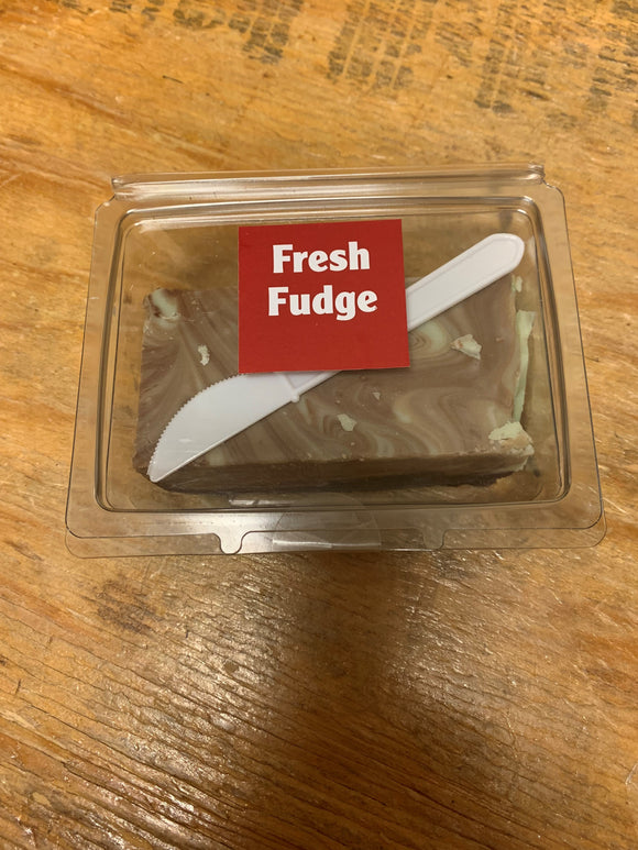 Small plastic hinged clamshell containing a block of chocolate mint swirled fudge